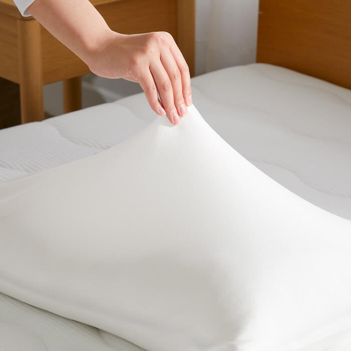 Dr.Bones Pillow for kumonoyasuragiの枕カバーをつまんでいるシーン